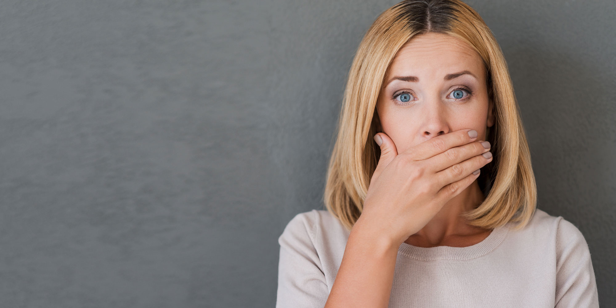 A patient covering her mouth, self-conscious about missing teeth