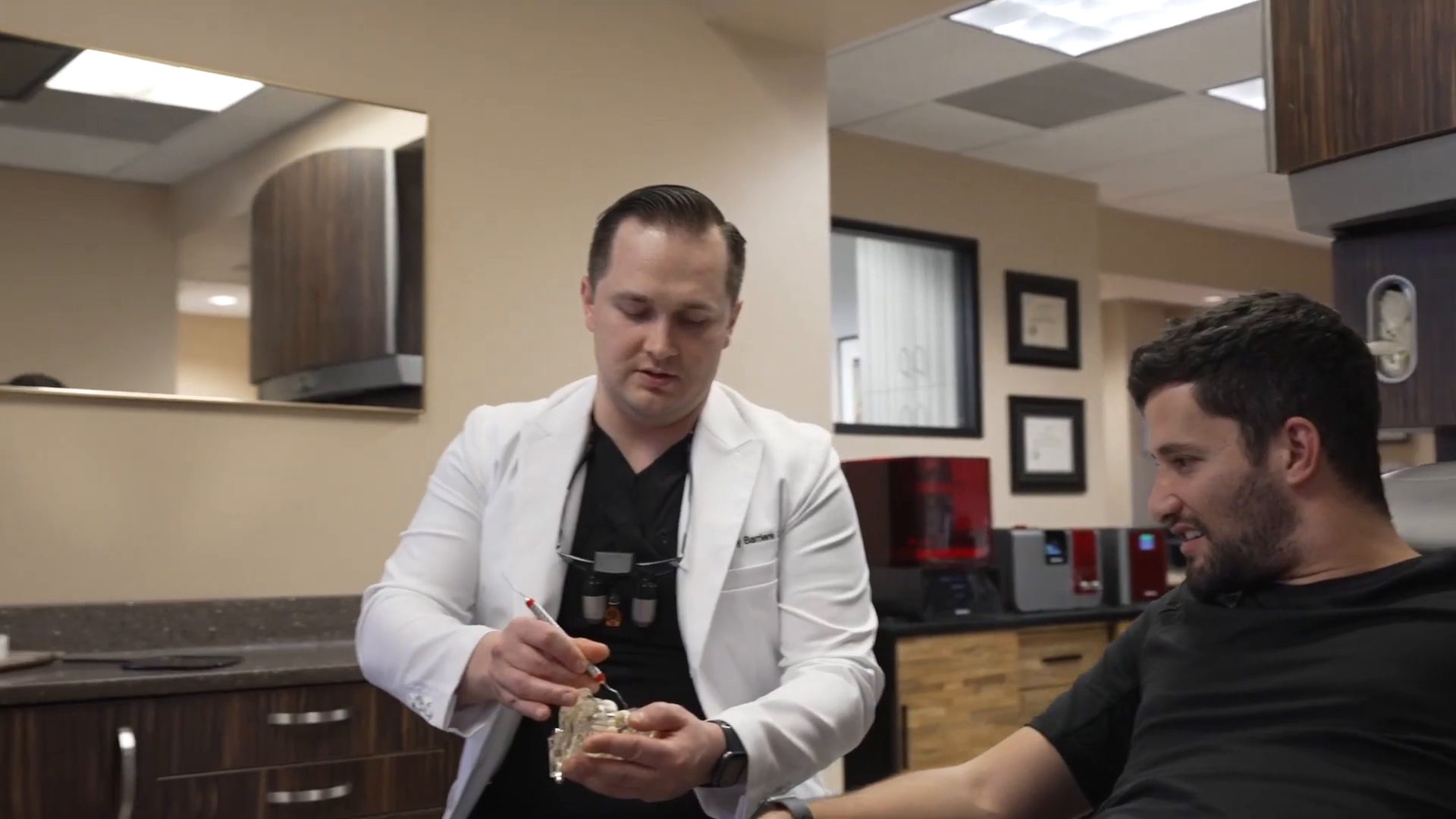 Dr. Tony Barriere showing a dental implant model during a consultation
