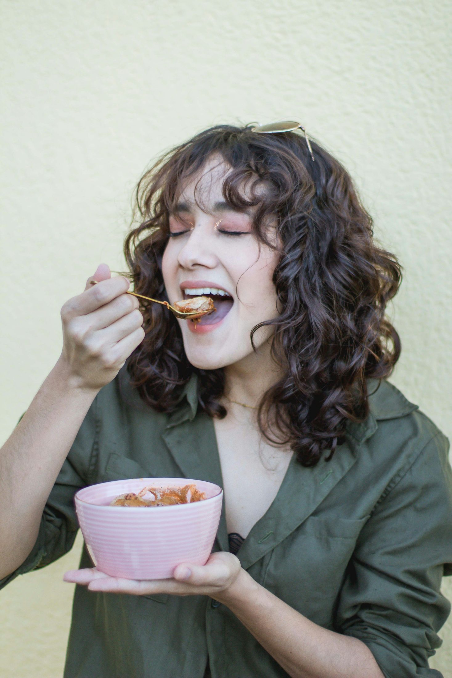 A woman eating a soft breakfast from a bowl