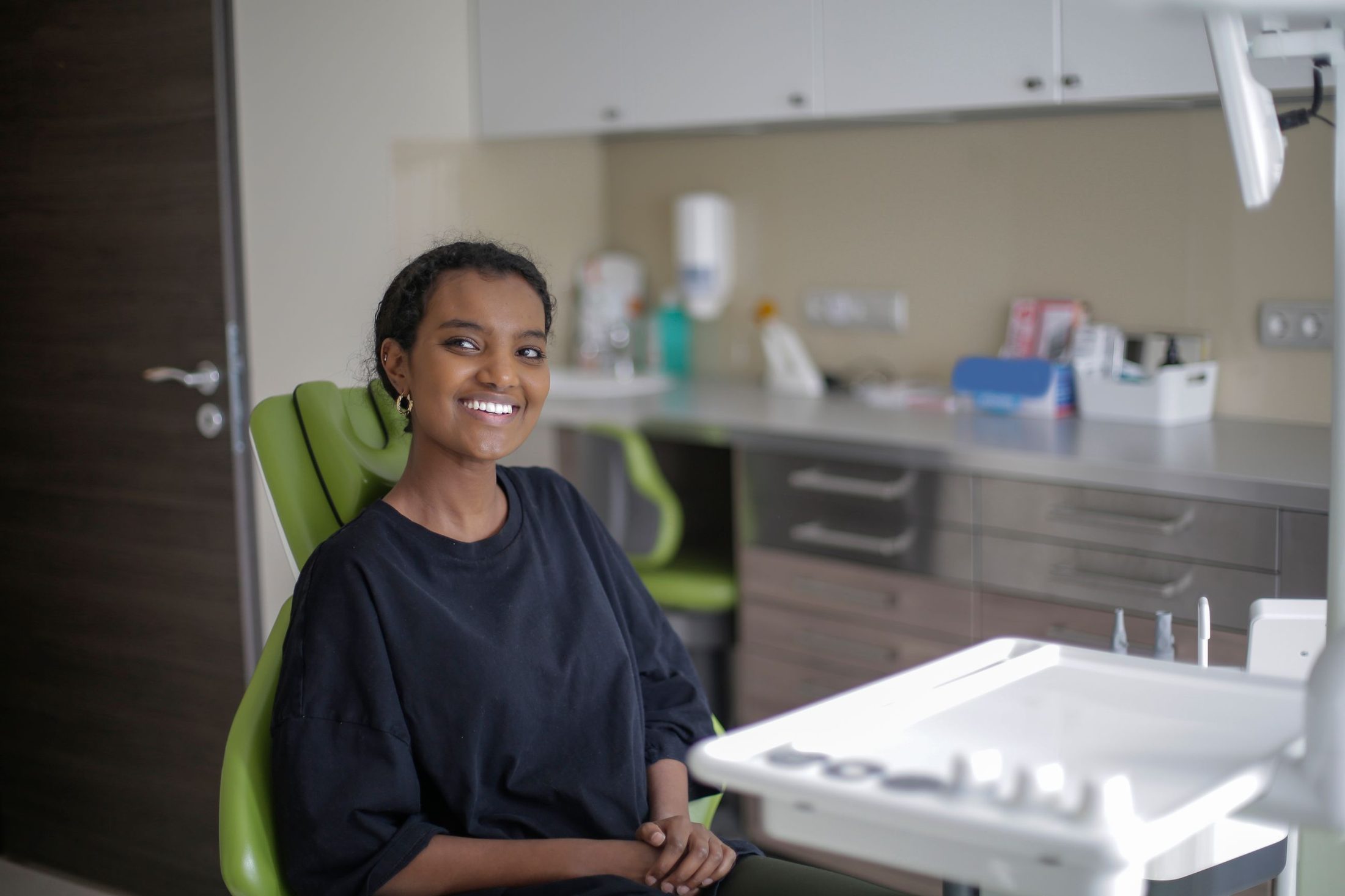 A smiling woman seated comfortably in a dental chair
