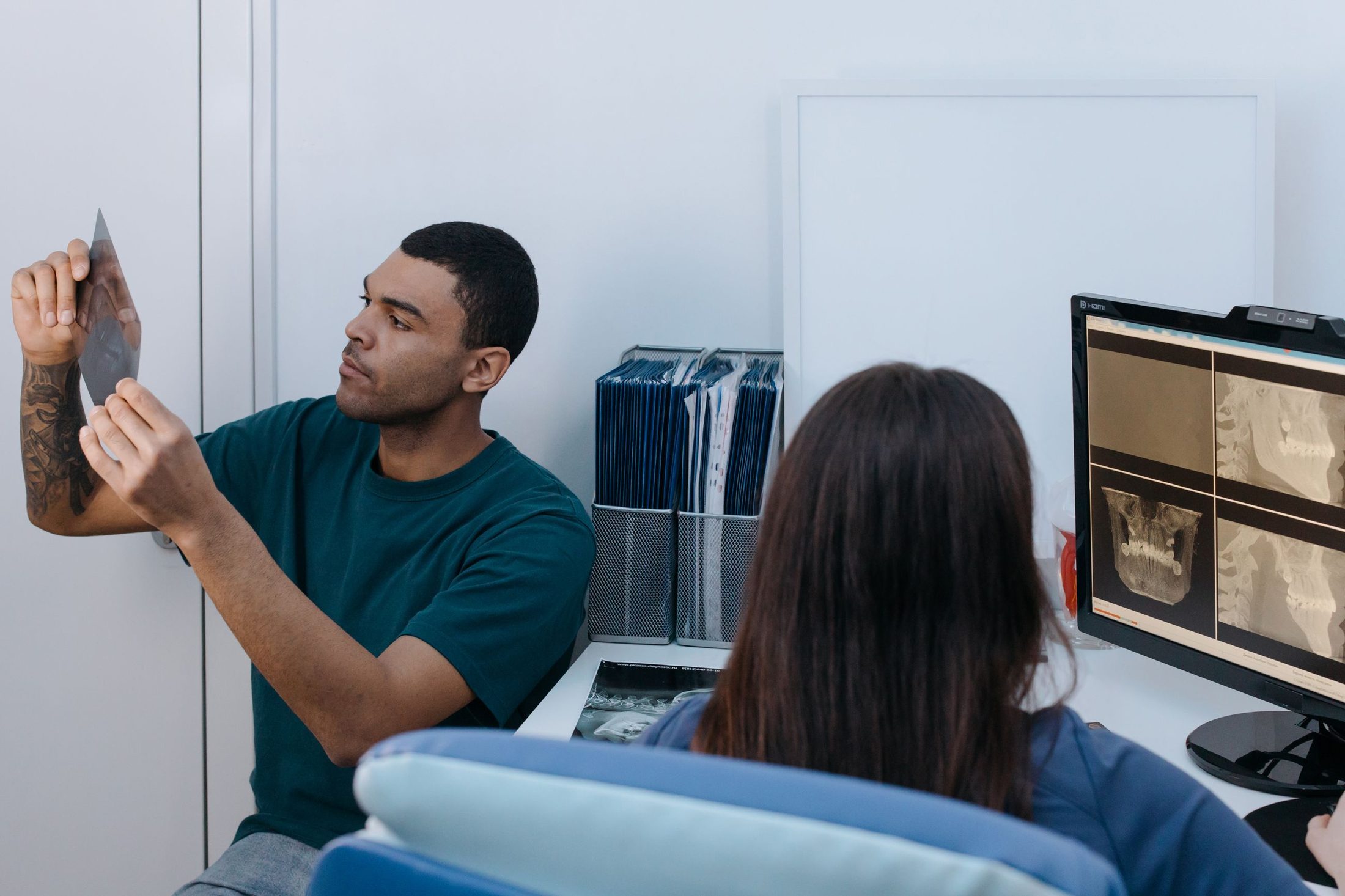 A dentist reviewing scans and X-rays with a patient