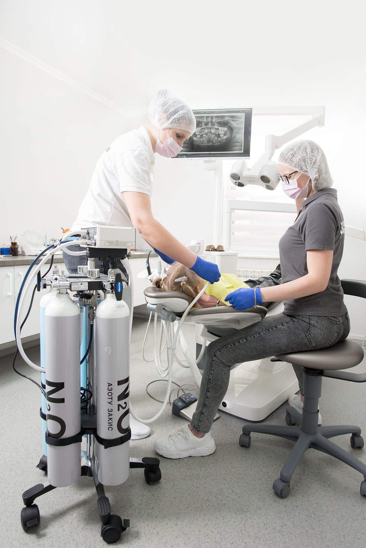 Nitrous oxide tanks beside the dental chair during treatment