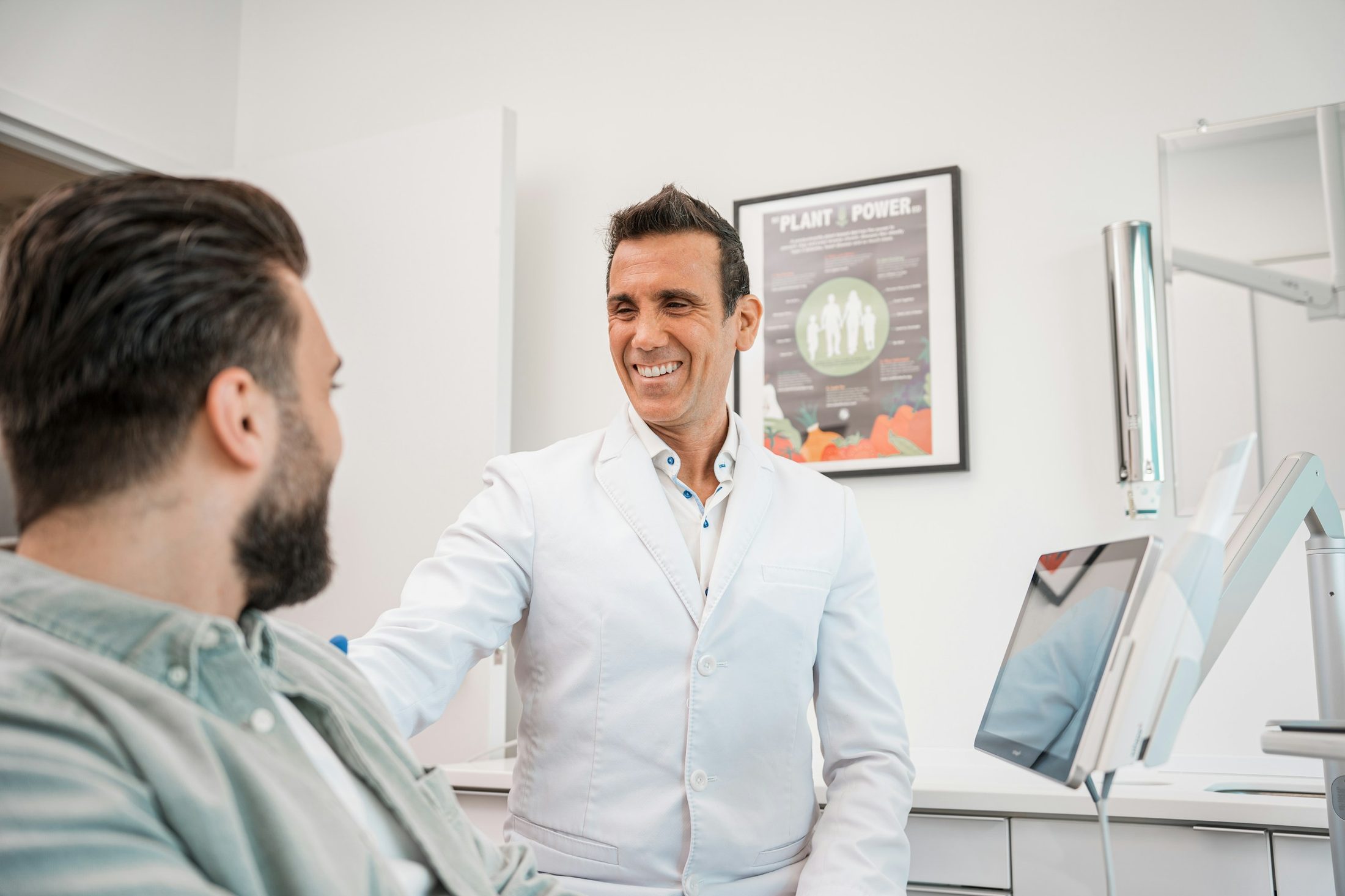 A smiling dentist talking through a plan with a patient
