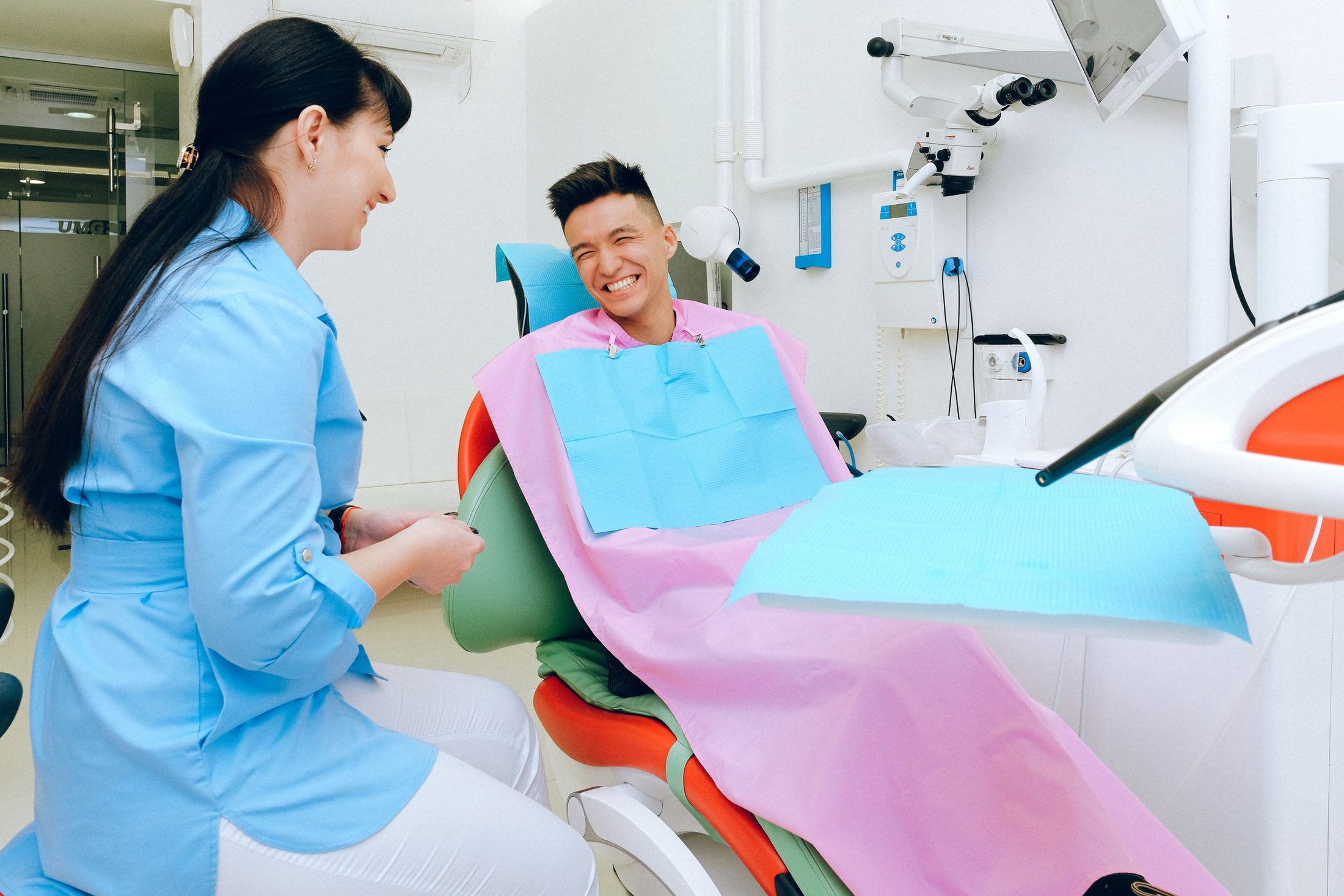 A hygienist with a smiling young patient in the chair
