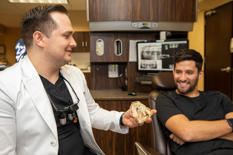 Dr. Barriere showing Michael a model of his new teeth