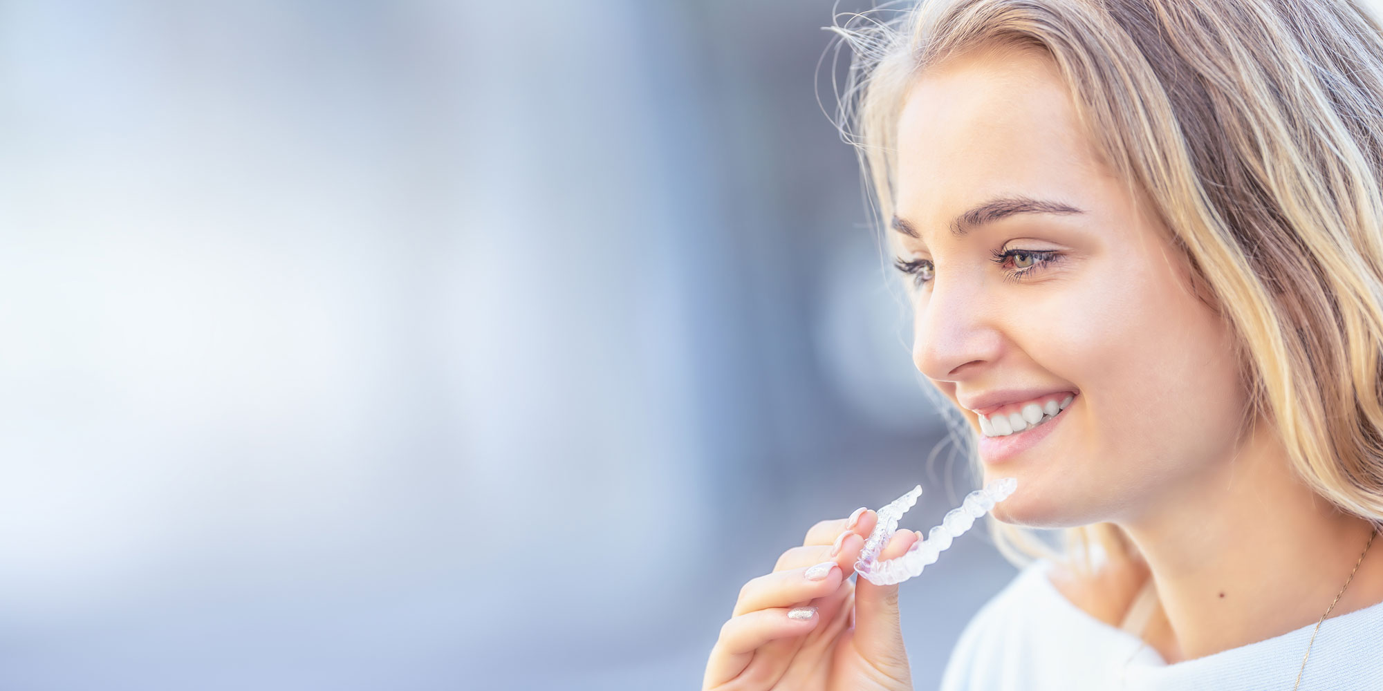 A patient fitting an Invisalign aligner