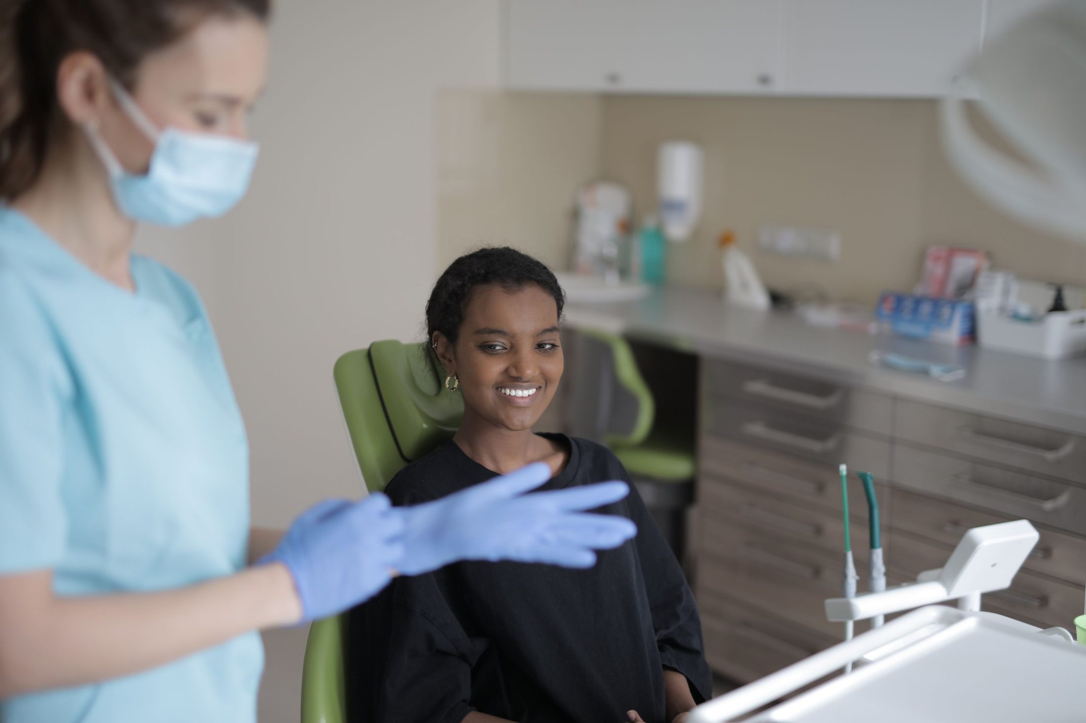 A hygienist preparing for a cleaning with a smiling patient