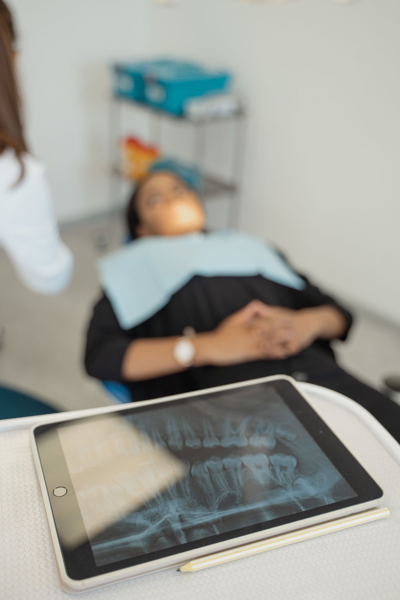 A patient's X-ray on a tablet beside the treatment chair