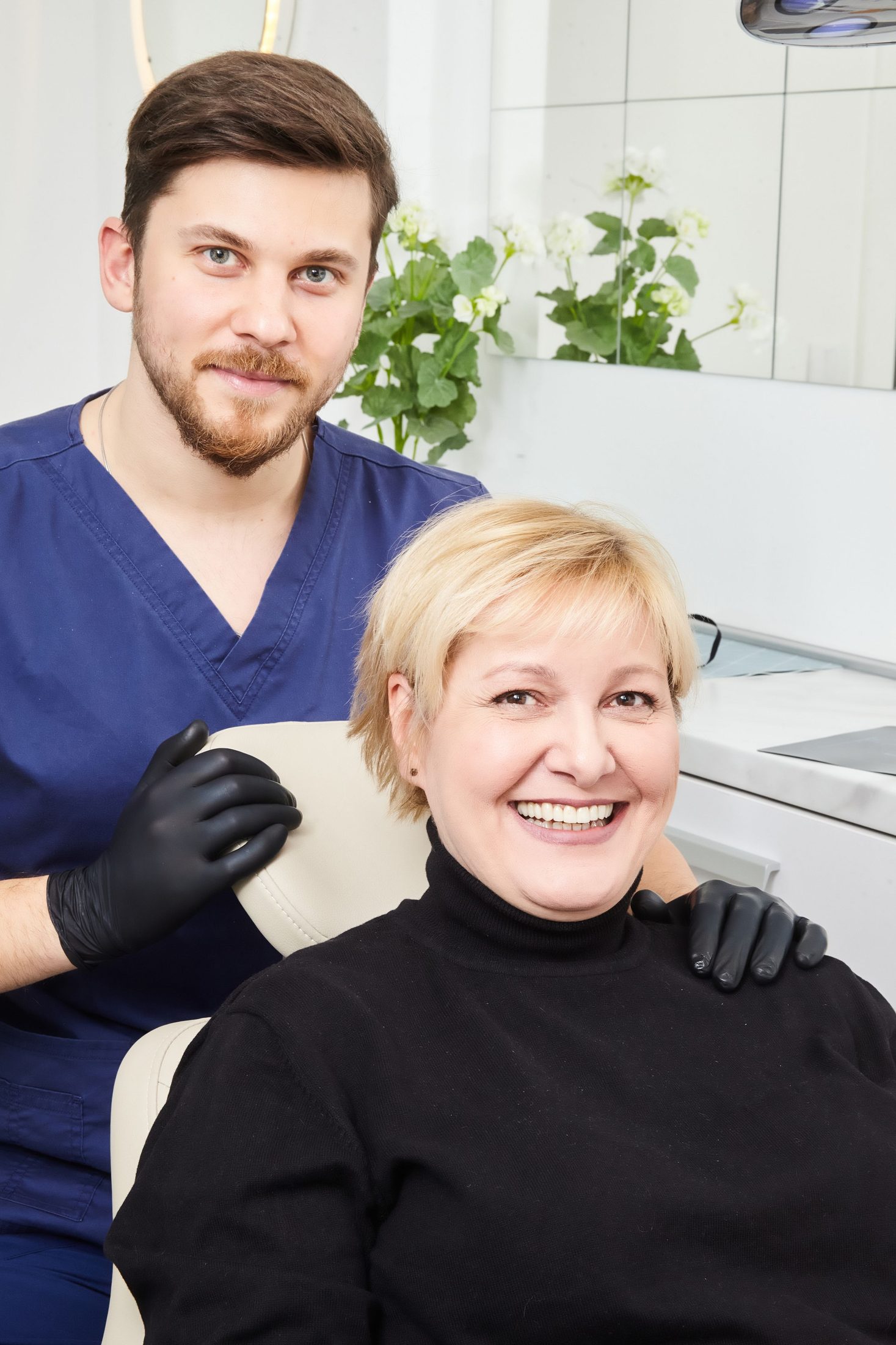 A smiling patient with her dentist after treatment